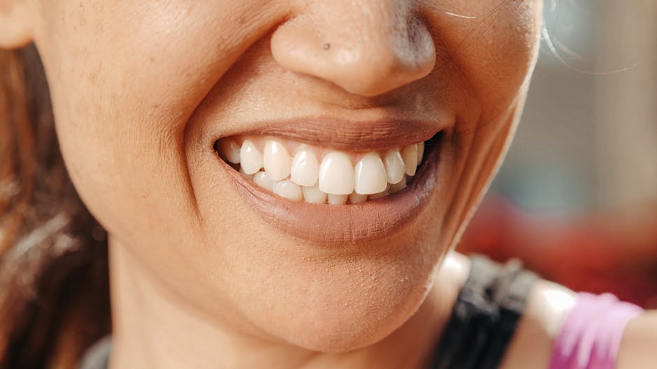 A close-up of a woman's smile, showcasing healthy teeth and natural skin tone.